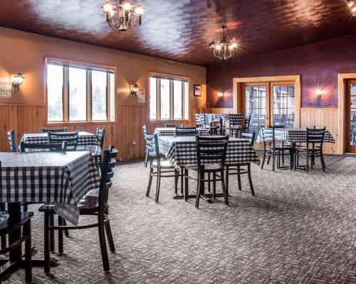 a restaurant with black and white tables and chairs at Quality Inn & Suites Munising in Wetmore