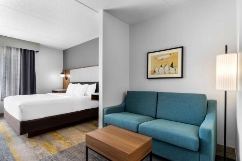Habitación de hotel con cama y sofá en Comfort Inn & Suites, en York