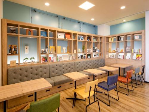 a restaurant with tables and chairs and books at Comfort Hotel Hamamatsu in Hamamatsu