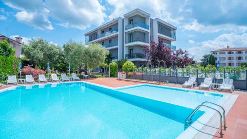 a swimming pool in front of a building at Hotel Bella Peschiera in Peschiera del Garda