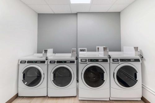 three washing machines in a laundry room at MainStay Suites Denver International Airport in Denver