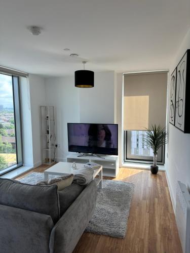 a living room with a couch and a large tv at Your private oasis in Manchester in Manchester