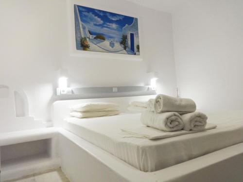 a white bedroom with a bed with towels on it at Paleochori Studios in Paliochori