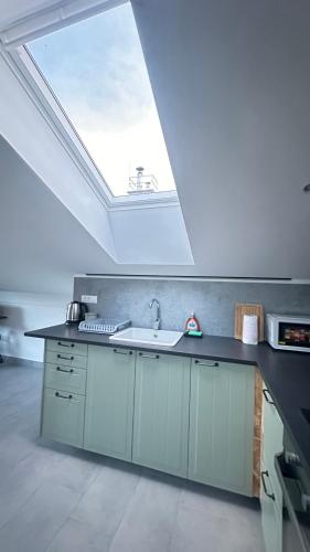 a kitchen with a sink and a skylight at OLD SQUARE HOUSE - HIŠA NA STAREM TRGU in Tolmin