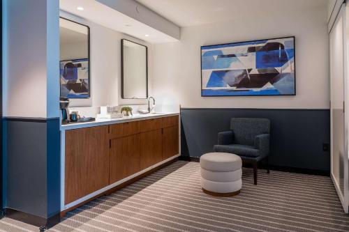 uma sala de espera com uma cadeira e um lavatório em Cambria Hotel Boston Somerville em Somerville