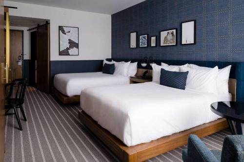 ein Hotelzimmer mit 2 Betten und einem Stuhl in der Unterkunft Cambria Hotel Boston Somerville in Somerville