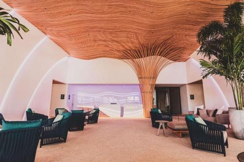 a lobby with chairs and a wooden ceiling at Radisson Blu Aruba in Palm-Eagle Beach