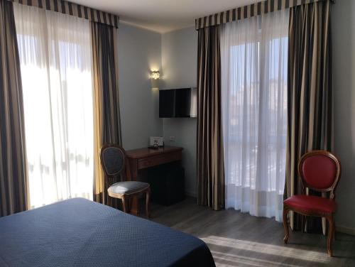 a hotel room with a bed and two chairs at Hotel Tiffany in Ceriale