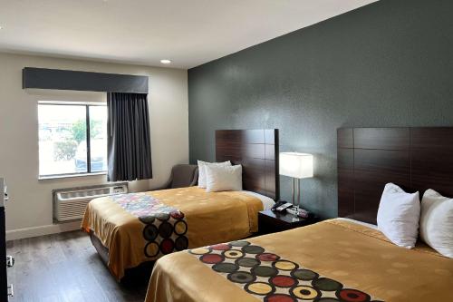 ein Hotelzimmer mit 2 Betten und einem Fenster in der Unterkunft Econo Lodge Beaumont I-10 South in Beaumont
