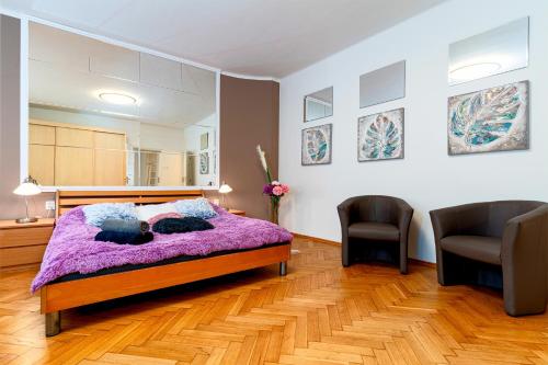 una camera con un letto viola e due sedie di Kingdom of Skylight a Praga