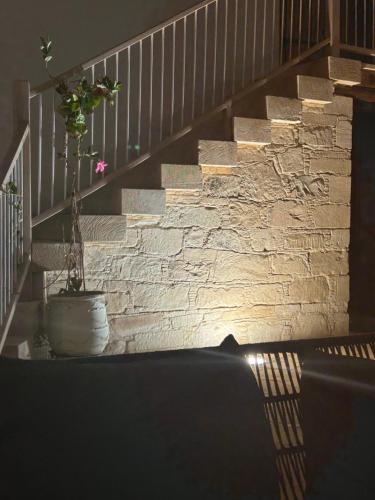 a stone wall with a staircase with a potted plant at Little Stone House in Lymbia