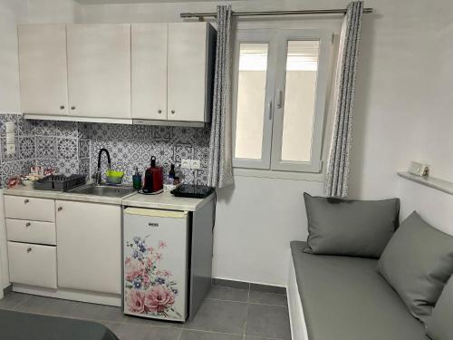 eine Küche mit einer Theke, einem Waschbecken und einer Couch in der Unterkunft Mykonos Secret Spot in Mykonos Stadt