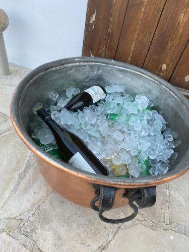 a pot filled with ice and a bottle of wine at Little Stone House in Lymbia