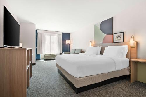 a hotel room with a large bed and a flat screen tv at Spark By Hilton Exton in Exton