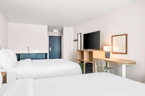 a hotel room with two beds and a desk at Spark By Hilton Exton in Exton