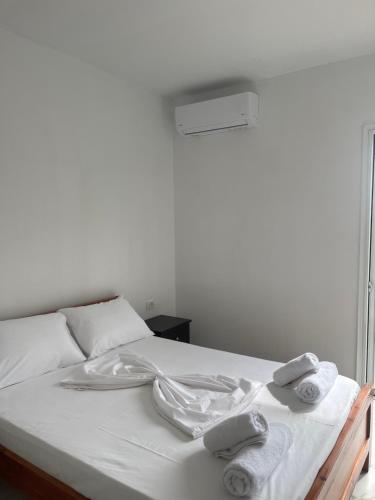 ヒマラにあるAmbelas Guest Rooms 5の白いベッド(タオル付)