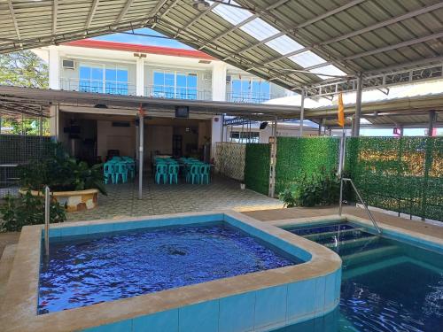 a large swimming pool with a patio with a table at Sakura's Pool and Leisure Hub in Puerto Princesa City