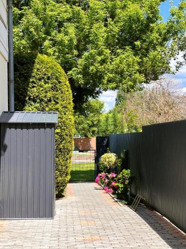 a fence with a brick walkway next to a garden at Panoráma Villa in Balatonboglár
