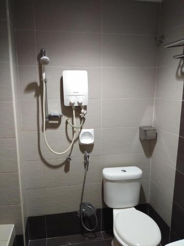 a bathroom with a toilet and a blow dryer at KL CITY LODGE in Kuala Lumpur