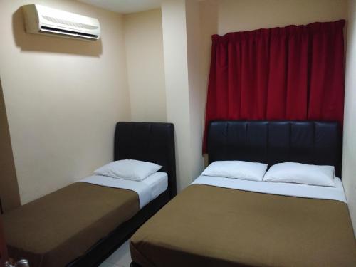 a room with two beds and a window with a heater at KL CITY LODGE in Kuala Lumpur