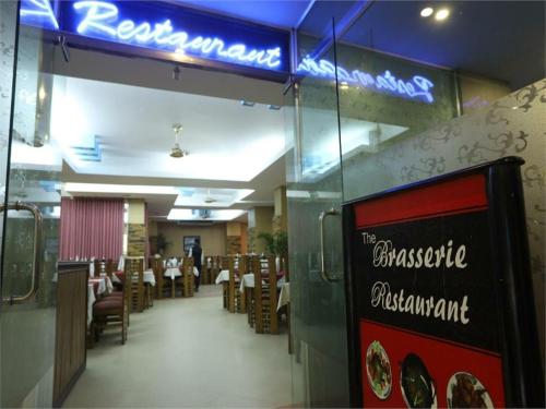 a restaurant with tables and chairs and a sign on the wall at Britannia Hotel in Sylhet