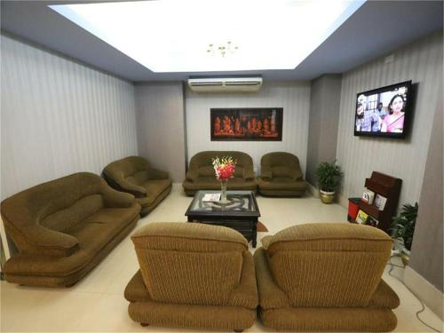 a living room with couches and a tv at Britannia Hotel in Sylhet