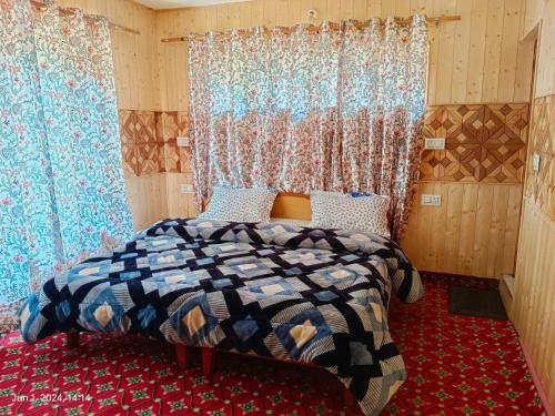a bedroom with a bed in a room with curtains at Green Street in Pahalgām