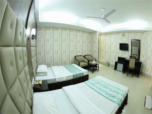 a hospital room with two beds and a television at Britannia Hotel in Sylhet