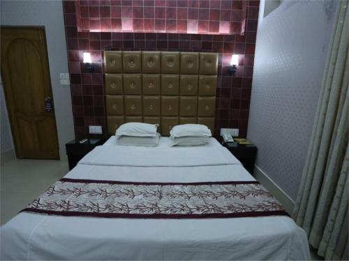 a bedroom with a large bed with a brick wall at Britannia Hotel in Sylhet