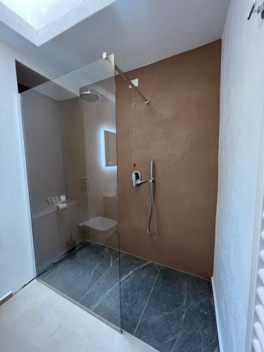a bathroom with a shower with a glass door at OSTERIA al CANTONACCIO ROOMS in Brusimpiano