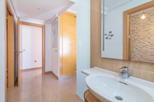 y baño con lavabo blanco y espejo. en Penthouse in the Sun en El Alquián