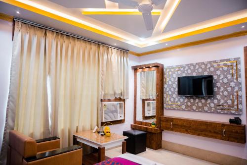 uma sala de estar com uma televisão e uma mesa em HOTEL COUNTRY INN em Dimāpur