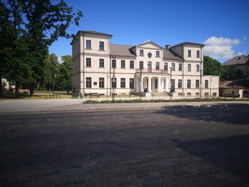 a large white building with a lot of windows at Aušros Alėjos Apartamentai in Šiauliai