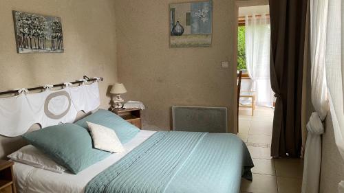 a bedroom with a bed with blue and white pillows at L'Orme Seul, Maison d'hôtes in Vineuil