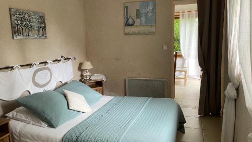 a bedroom with a bed with blue and white pillows at L'Orme Seul, Gîte in Vineuil