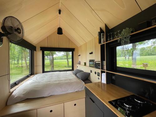 um quarto com uma cama numa pequena casa em L'Envolée Ecolodge, tiny house au coeur des vignes em Loches-sur-Ource