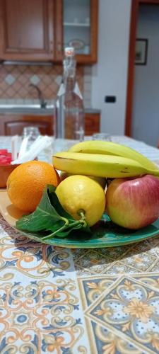 a plate of fruit on a counter with bananas and apples at B&B DA SILVESTRO in Tempio Pausania