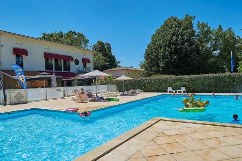 une grande piscine avec des gens dans l'eau dans l'établissement Villa Bordeaux, à Salles