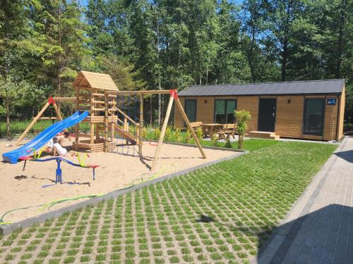 a child playing on a slide in a playground at Domki Wakacyjne "Morskie Wrota"Karwieńskie Błota in Karwieńskie Błoto Drugie
