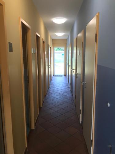a hallway with many doors and a tile floor at Glampingpod in Loitz