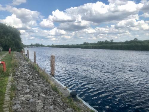 a body of water with a person walking next to it at Glampingpod in Loitz