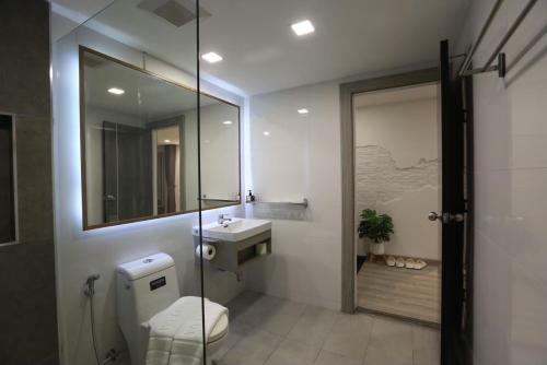 曼谷的住宿－U42 Hotel Bangkok，一间带卫生间、水槽和镜子的浴室