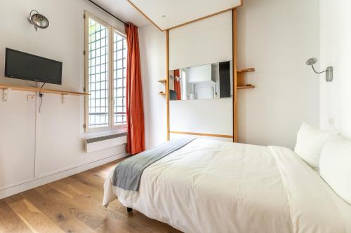 une chambre avec un lit et un grand miroir dans l'établissement Matignon Cozy Flat, à Paris