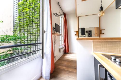 Il dispose d'une cuisine avec un balcon offrant une vue sur un bâtiment. dans l'établissement Matignon Cozy Flat, à Paris