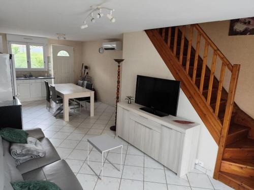Il comprend un salon doté d'un canapé, d'une télévision et d'un escalier. dans l'établissement Maisonnette à 5 minutes d'Albi, à Carlus
