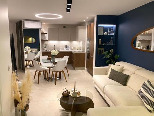 un salon avec un canapé et une salle à manger dans l'établissement Appartement luxe vue mer et collines avec piscine, à Mandelieu-la-Napoule