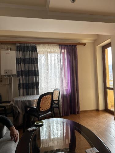 a living room with a table and a window at Appartment in Tsakhkadzor Mori Plaza in Tsaghkadzor