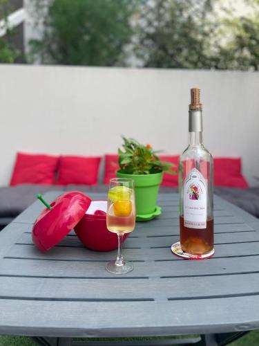 une bouteille de vin et un verre sur une table dans l'établissement Appartement T3 de standing tout équipé, à Collioure