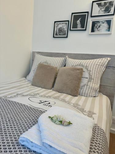 a bed with towels and pictures on the wall at Une Chambre dans un appartement in Ablon-sur-Seine