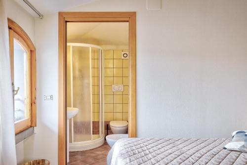 a bathroom with a shower and a bed in a room at Affittacamere nel cuore della Toscana a 20 minuti da Firenze in Empoli